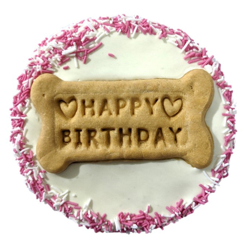 Dog birthday cake with a bone-shaped cookie displaying 'Happy Birthday' on a white background